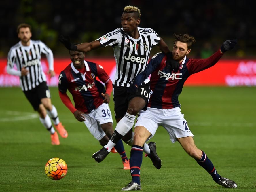 Paul Pogba (m.) speelt alsof Luca Rizzo (r.) niet bestaat. De Fransman springt behendig langs zijn tegenstander tijdens de wedstrijd Bologna - Juventus. (19-02-2016)