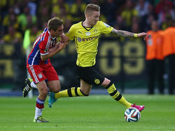 Philipp Lahm (l.) würde gern in der Bundesliga weiter gegen Marco Reus um den Ball kämpfen