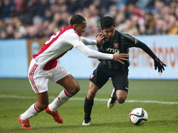 Kenny Tete (l.) heeft in al zijn onervarenheid heel veel moeite met Jesús Corona tijdens Ajax - FC Twente. De Mexicaan snelt hier langs de rechtsback heen. (15-02-2015)