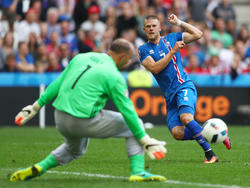 Jóhann Berg Guðmundsson probeert doelman Gabor Kiraly te passeren tijdens het EK-groepsduel tussen IJsland en Hongarije. (18-06-2016)