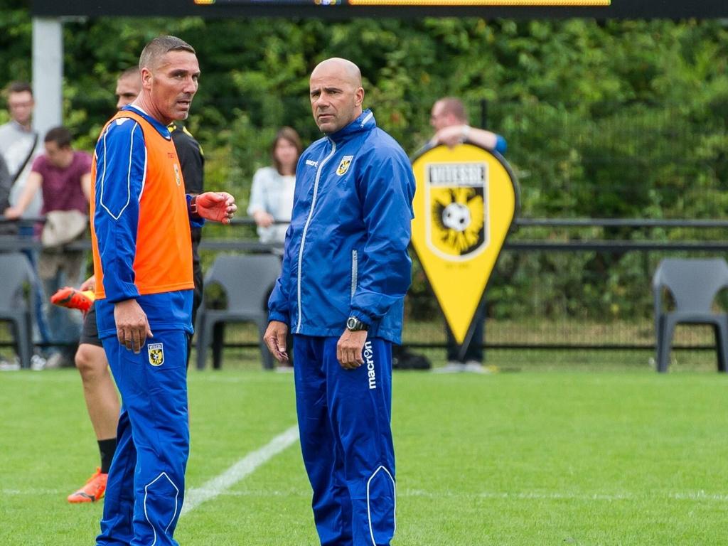 Een deel van de trainersstaf overlegt op de training van Vitesse. Hier praten Peter Bosz (r.) en Hendrie Krüzen.