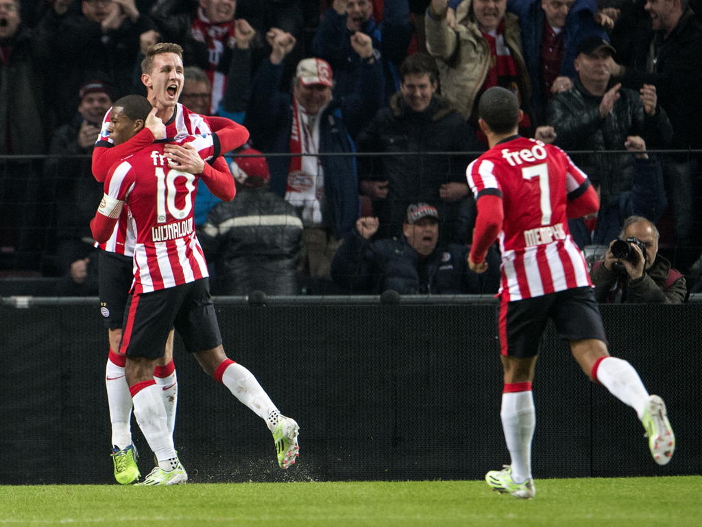 Luuk de Jong (l.) viert de 1-1 van PSV tegen Feyenoord met Georginio Wijnaldum (10). Memphis Depay (r.) wil het feestje ook meevieren. (17-12-2014)