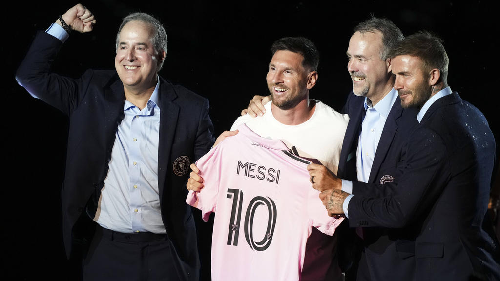 America's No. 10: Argentine soccer star Lionel Messi is presented by Inter Miami owners David Beckham, Jose R. Mas and Jorge Mas as the Major League Soccer club's new star Fans dance under the rain outside DRV PNK Stadium in Fort Lauderdale, Florida, where Argentine star Lionel Messi was introduced by hs new club Inter Miami of Major League Soccer Fans carry a cardboard cutout of Lionel Messi outside DRV PNK Stadium before the star was presented to supporters following his move to Inter Miami of Major League Soccer