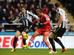 Dani Osvaldo (m.) in duel met Davide Santon (l.) en Mike Williamson (r.) tijdens Newcastle United - Southampon. (14-12-2013)