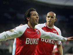 Mounir El Hamdaoui (l.) viert zijn treffer in dienst van AZ met Simon Poulsen. De aanvaller scoort de openingstreffer tegen FC Twente. (13-04-2010)