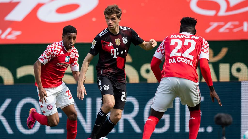 Bayerns Thomas Müller (M.) behauptet gegen die Mainzer Leandro Barreiro Martins (l.) und Danny da Costa (r.) den Ball Bayerns Thomas Müller (M.) behauptet gegen die Mainzer Leandro Barreiro Martins (l.) und Danny da Costa (r.) den Ball
