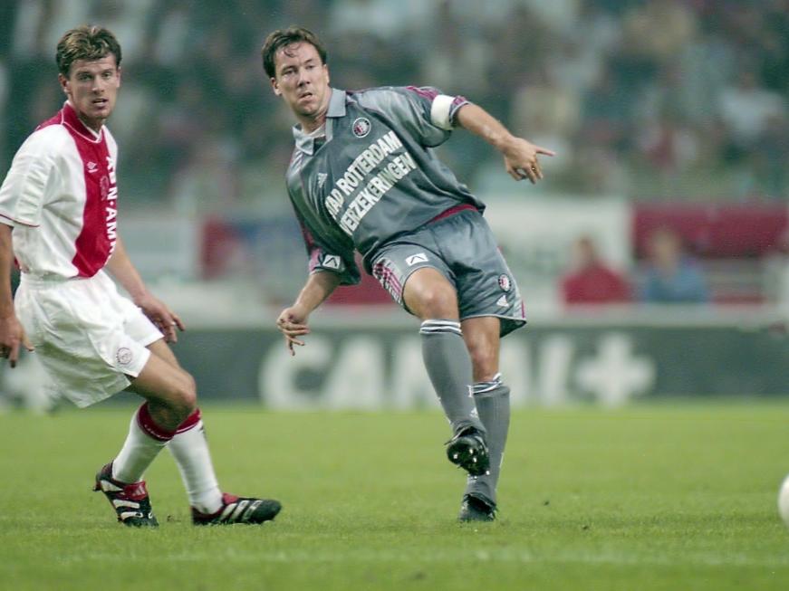 Richard Knopper kan alleen maar toekijken hoe Jean Paul van Gastel een pass verstuurt tijdens Ajax - Feyenoord. (10-09-1999)