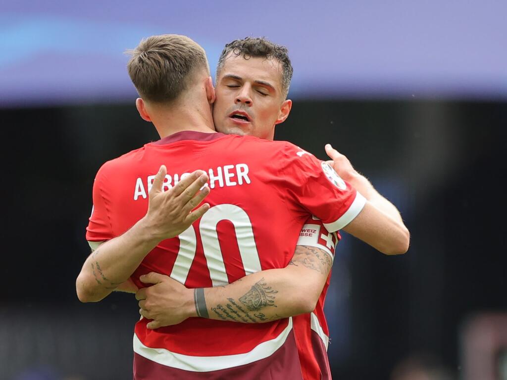 Die Schweizer Michel Aebischer (l) und der Granit Xhaka umarmen sich nach dem Spiel