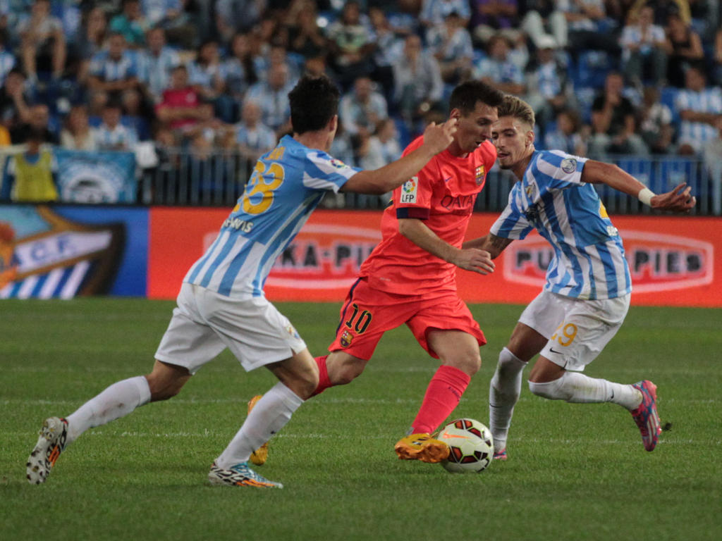 Lionel Messi (m.) wird im Spiel gegen Malaga gedoppelt