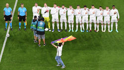 Ein junger Mann rannte mit einer Regenbogenfahne über das Spielfeld