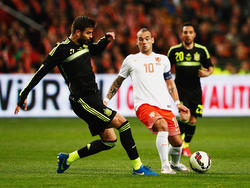 Wesley Sneijder (r.) probeert met man en macht de bal buiten bereik van Gerard Piqué (l.) te houden in het interlandduel met Spanje. (31-03-2015)