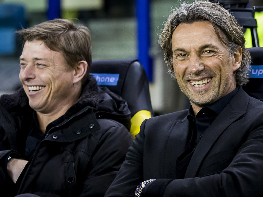 Jon Dahl Tomasson (l.) en Rob Maas (r.) hebben veel plezier op de bank bij Vitesse tijdens de wedstrijd tegen PEC Zwolle. (27-01-2016)