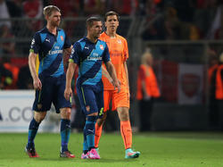Per Mertesacker (l.) spricht sich gegen einen Wechsel von Lukas Podolski (M.) aus