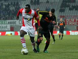 Kelvin Maynard (l.) is niet onder de indruk van Deniz Türüç (r.), die druk probeert te zetten op de verdediger van FC Emmen. (08-03-2013)