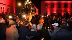 Zahlreiche Menschen umringen die frisch enthüllte Gerd-Müller-Statue in Nördlingen