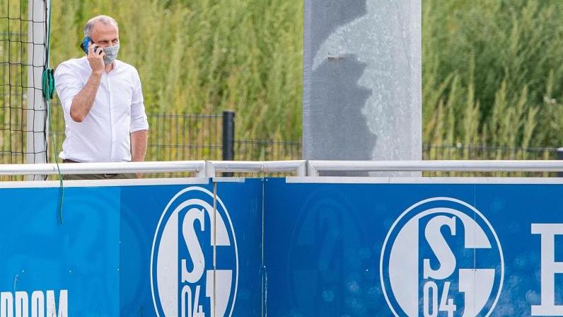 Sportvorstand Jochen Schneider vom FC Schalke 04 steht beim Training hinter einer Bande und telefoniert
