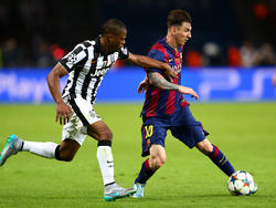 Patrice Evra (l.) zet de achtervolging in op Lionel Messi (r.) in de finale van de Champions League. (06-06-2015)