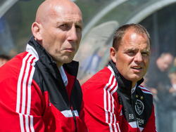 Jaap Stam (l.) en Frank de Boer aanschouwen samen vanuit de dug-out een oefenwedstrijd van Ajax tegen SDC Putten. (29-06-2013). 
