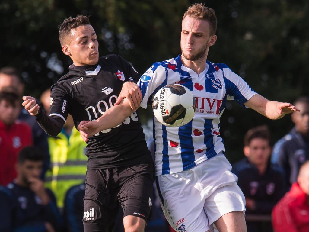 Tijdens de oefenwedstrijd tussen sc Heerenveen en FC Emmen gaat Henk Bos (l.) het duel aan met Branco van den Boomen (r.). (08-07-2016)
