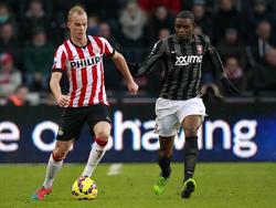 Kyle Ebecilio (r.) doet zijn best om Jorrit Hendrix bij te houden tijdens het competitieduel PSV - FC Twente. (14-12-2014)