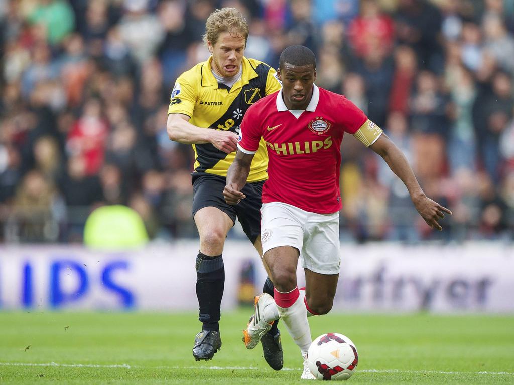 Tim Gilissen (l.) probeert de bal van Georginio Wijnaldum (r.) af te pakken tijdens PSV - NAC. (3-5-2014)