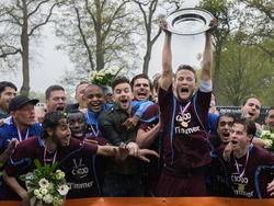 Na de wedstrijd tegen HSC '21 weet FC Lienden dat het kampioen is geworden in de Topklasse Zondag. Mike Vreekamp (m.) mag als aanvoerder de schaal boven het hoofd houden. (03-05-2015)