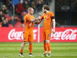 Wesley Sneijder (l.) moet tegen Frankrijk het veld al vroeg verlaten met een blessure en geeft zijn aanvoerdersband aan Daley Blind. (25-03-2016)