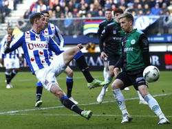 Mark Uth (l.) gebruikt zijn slimheid als spits en komt tijdens sc Heerenveen - FC Groningen voor Rasmus Lindgren (r.), maar de poging van de aanvaller mist doel. (22-02-2015)