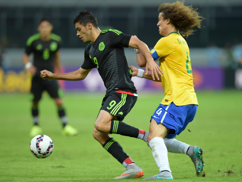 Raúl Jiménez (izq.) y David Luiz luchan por la posesión en un México-Brasil. (Foto: Getty)