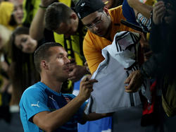 Lukas Podolski gibt in Dortmund Autogramme auf WM-Trikots