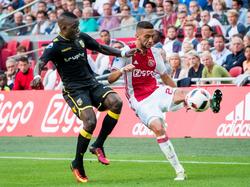 Ajax-debutant Hakim Ziyech (r.) vecht een duel uit met Marvelous Nakamba (l.) tijdens het competitieduel Ajax - Vitesse (11-09-2016).