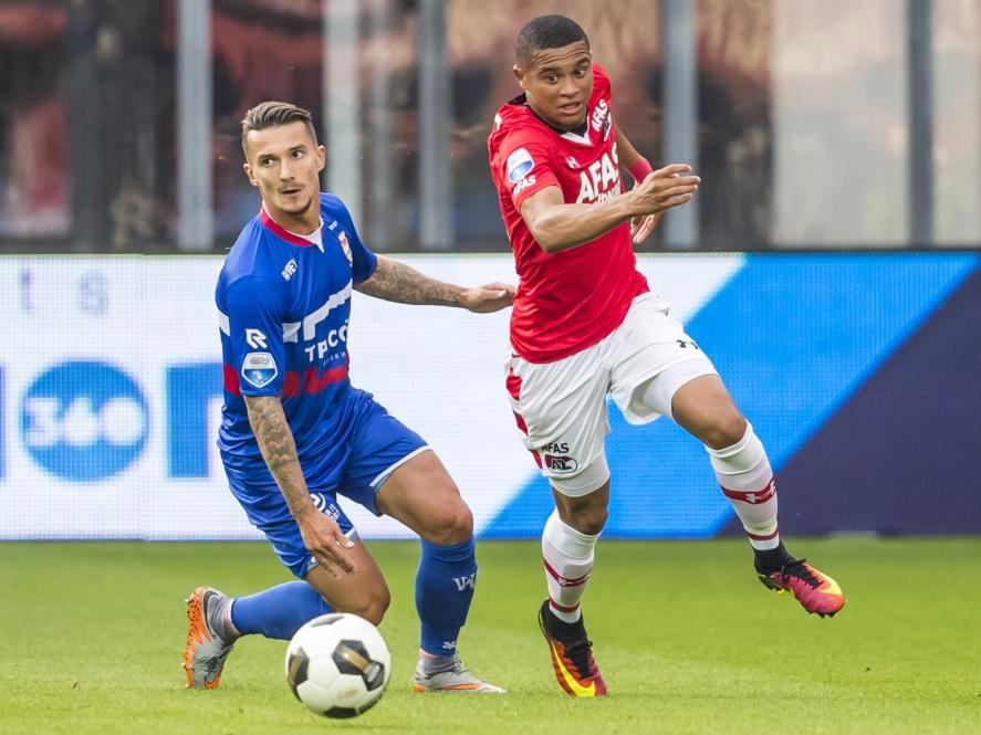 Dabney dos Santos (r.) snelt langs debutant Jordy Croux (l.) tijdens het competitieduel AZ Alkmaar - Willem II (10-09-2016).