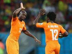 Wilfried Bony (r.) viert de 1-1 samen met Souleymane Bamba (l.). (15-06-2014) 