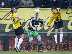 De NAC Breda-spelers Kenny van der Weg (l.) en Uros Matic (r.) komen te laat om Feyenoord Lex Immers (m.) het koppen te beletten. (21-12-2014)