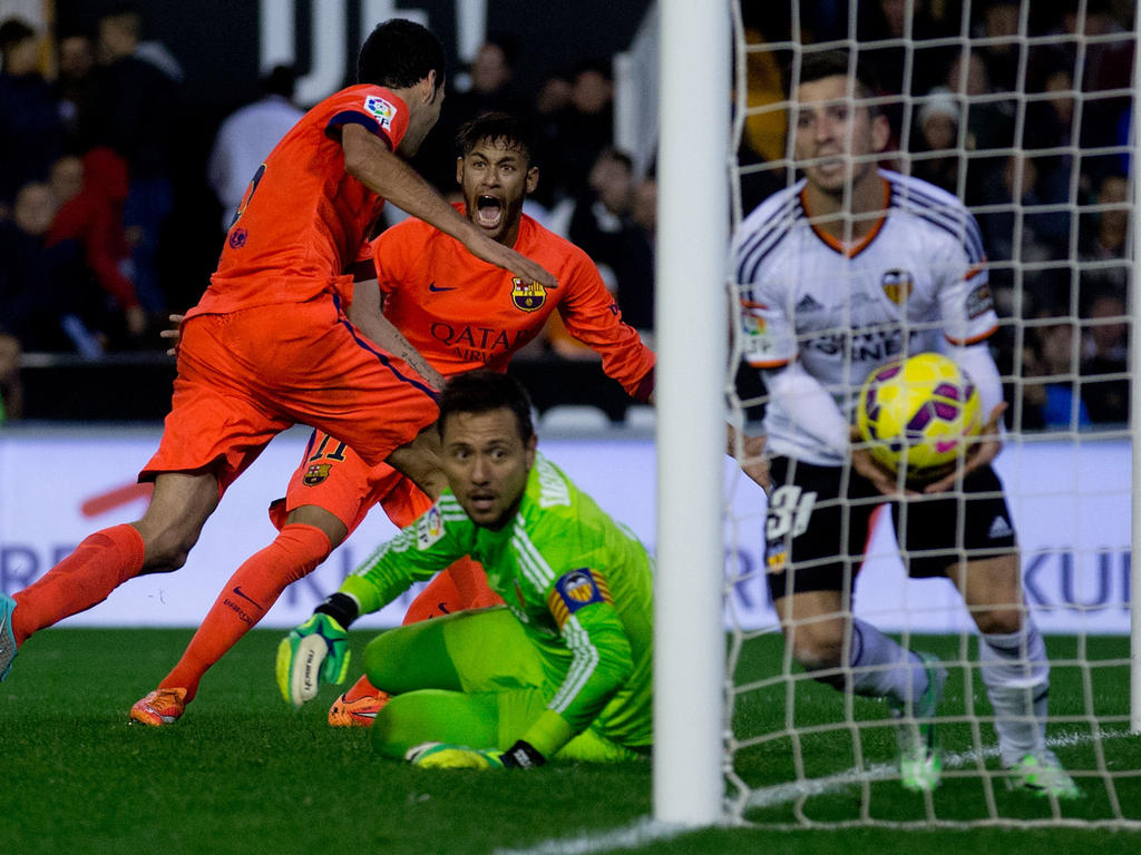Valencia doelman Diego Alves kijkt kansloos toe hoe Sergio Busquets de rebound van Neymar binnen schiet. (30-11-14)