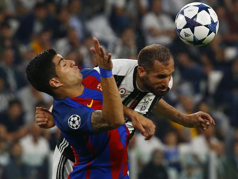 Chiellini kopt de bal weg in het duel met FC Barcelona-speler Luis Suárez