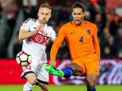Virgil van Dijk (r.) ruimt op, voordat Sergey Krivets aan de bal kan komen tijdens de interland Nederland - Wit-Rusland. (07-10-2016)