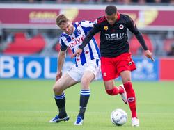 Brandley Kuwas (r.) dribbelt met de bal aan de voet. De buitenspeler wordt echter op de huid gezeten door SC Heerenveen-aanvoerder Joey van den Berg. (17-04-2016)