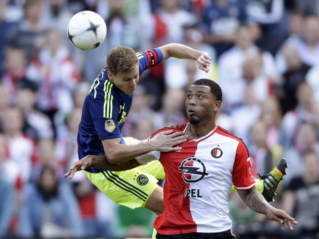 Niklas Moisander (l.) springt tijdens Feyenoord - Ajax tegen 'muur' Colin Kâzim-Richards (r.) op. (21-09-2014)