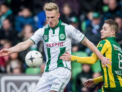 Nick van der Velden (l.) neemt in de wedstrijd FC Groningen - ADO Den Haag de bal zo goed aan, dat Aaron Meijers er niet meer bij kan. (01-03-2015)