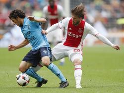 Lasse Schöne (r.) tikt de bal bij de voeten van Yassin Ayoub (l.) weg tijdens Ajax - FC Utrecht. (02-10-2016)
