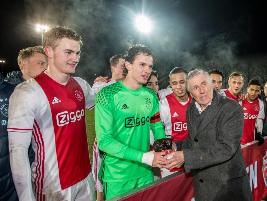 Niemand minder dan Sjaak Swart (r.) overhandigt aanvoerder Norbert Alblas (m.) de eerste bronzen stier voor Jong Ajax. De beloften pakten tegen FC Eindhoven (1-1) de eerste periodetitel in de clubgeschiedenis. (24-02-2017)