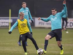 Menno Koch (r.) en Oleksandr Zinchenko (l.) komen tegelijkertijd bij de bal tijdens een training van PSV. (10-02-2017)