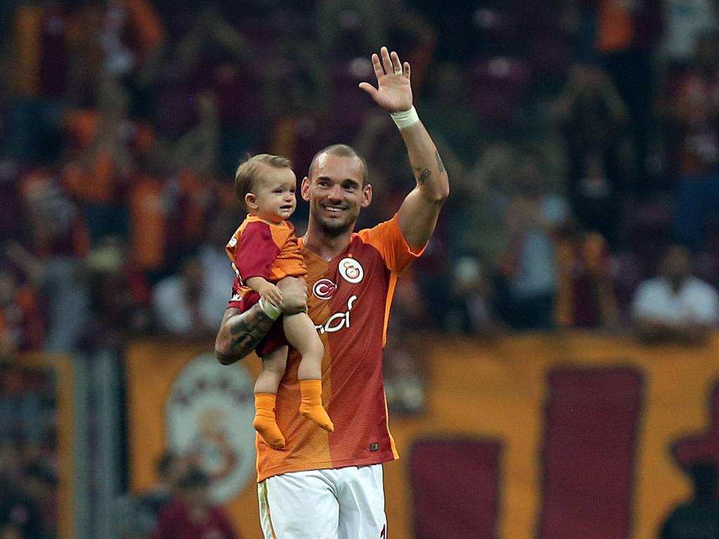 Met een glimlach op het gezicht en zijn dochter in zijn armen zwaait Wesley Sneijder naar de fans van Galatasaray na de wedstrijd tegen Çaykur Rizespor. (17-09-2016)