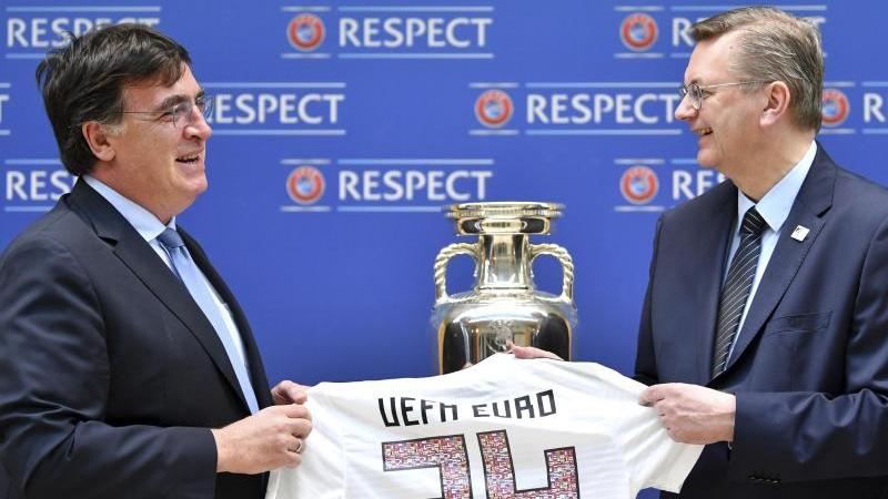 DFB-Präsident Reinhard Grindel (r.) übergibt die Bewerbungsunterlagen für die EM 2024