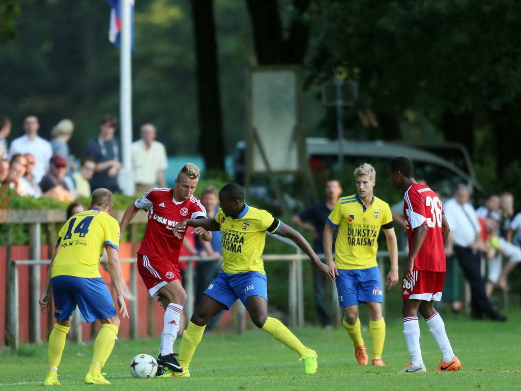 Almere City en SC Cambuur spelen tegen elkaar in de voorbereiding op het seizoen 2014/2015. Hier gaat Fabian Serrarens (m.) langs Oebele Schokker (l.) en Calvin Mac-Intosh (r.). (23-07-2014)