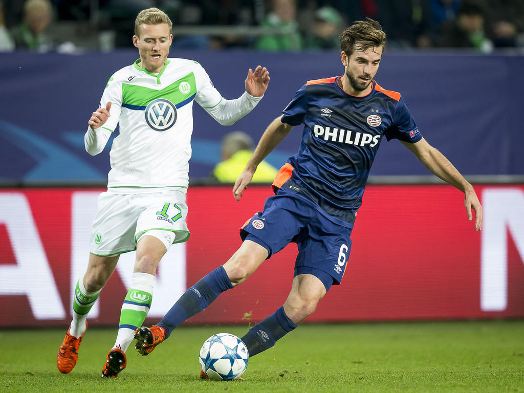 André Schürrle (l.) moet in de achtervolging bij Davy Pröpper (r.) tijdens het Champions League-duel VfL Wolfsburg - PSV (22-10-2015).