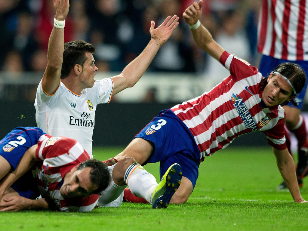 Reals Madrids Gareth Bale (M.) und Atléticos Diego (l.) Godin gehen nach einem Zweikampf zu Boden