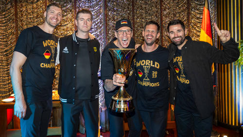 Basketball-Bundestrainer Gordon Herbert (m.) jubelt mit dem WM-Pokal