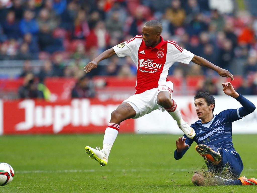 Thulani Serero (l.) haalt verwoestend uit na een afgeslagen corner en zet Ajax zo op 1-0 tegen FC Utrecht. Christian Kum is te laat met zijn sliding. (14-12-2014)